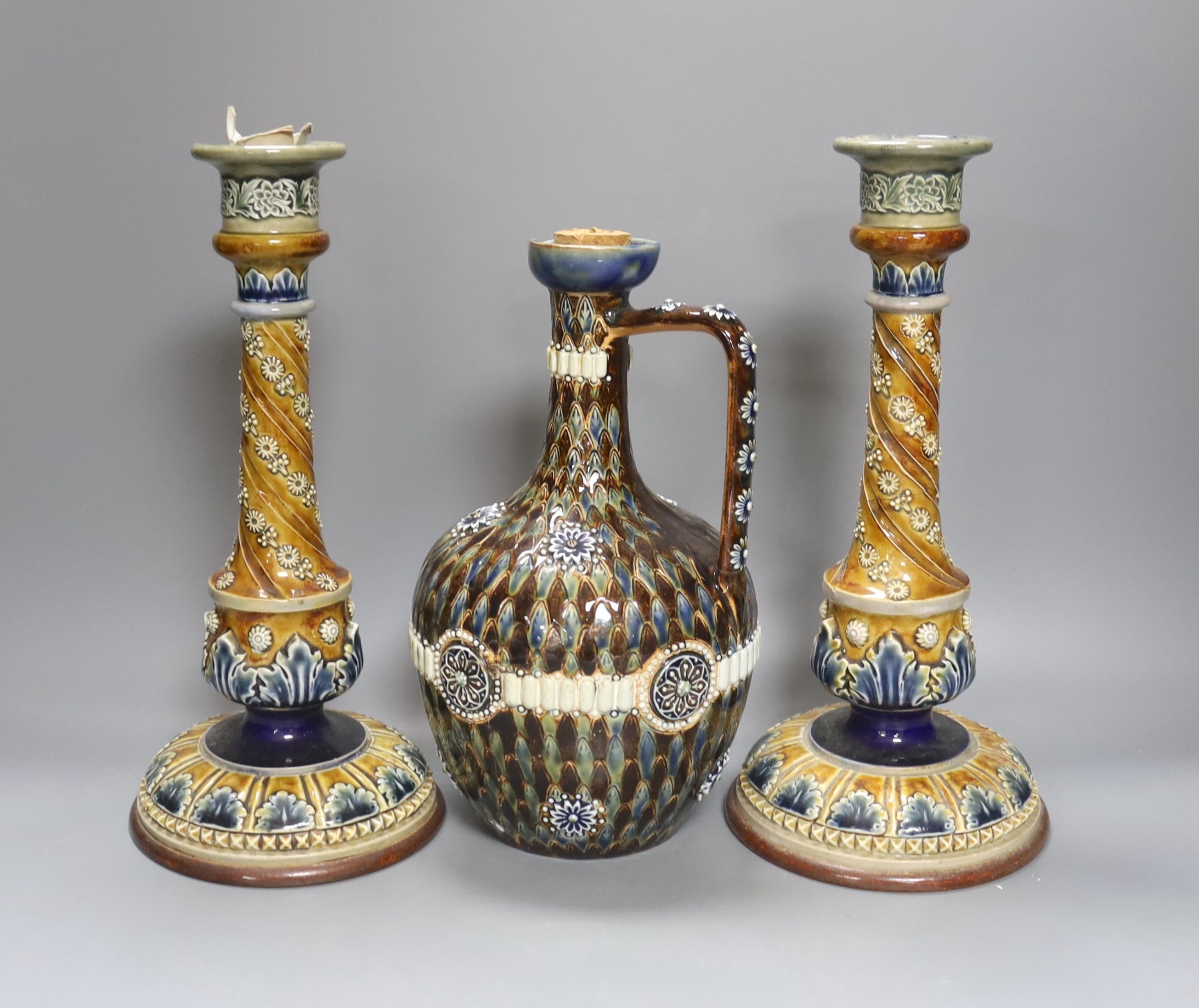 A pair of Doulton Lambeth stoneware candlesticks, height 30cm, and a similar 1878 ewer (cracked)
